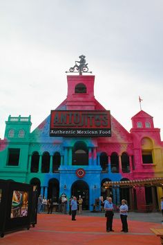 people are standing in front of the colorful building