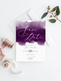 wedding save the date card with purple watercolor background and calligraphy on white paper