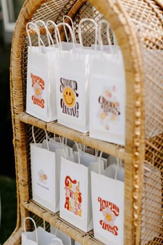 some bags are hanging on a wicker rack