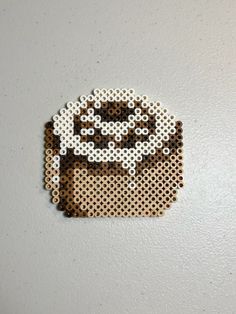 a piece of perler bead art with a coffee cup on it's side