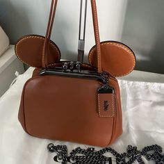 Authentic Retail Version Sold Out In Stores And Online Glovetanned Leather Inside Multifunctional Pocket Double Kisslock Closure, Leather Lining Handle With 4 1/2 Drop Detachable Strap With 22 1/2” Drop For Shoulder Or Crossbody Wear 6” X 4.25” X 3.75” Disney X Coach Retail For $528 + Tax Comes With Dust Bag Never Used, Floor Model, Priced Accordingly Disney Coach, Minnie Mouse Ears, Mouse Ears, Coach Bags, Minnie Mouse, Vision Board, Crossbody Bag, Dust Bag, Bag Lady