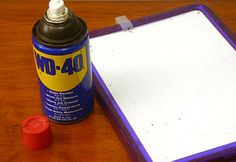 a bottle of glue sitting on top of a wooden table next to a clipboard