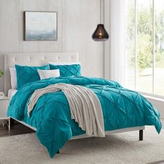 a bed with blue comforters and pillows in a room