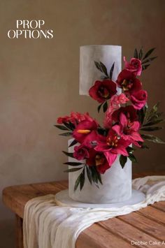 a white cake with red flowers on top and the words prop options written above it