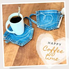 a cup of coffee sitting on top of a wooden table next to a pair of jeans