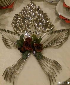 there is a silver plate with flowers on it and forks in the shape of a butterfly