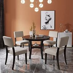 a dining room table with four chairs and a painting on the wall in the background