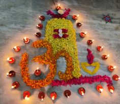 an image of a decorated number with candles around it on the ground in front of them