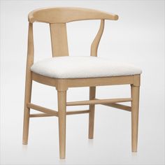 a wooden chair with a white cushion on the seat and backrest, against a white background