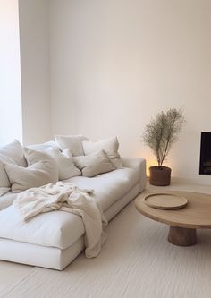 a living room with a white couch, coffee table and television