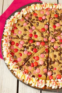 a chocolate chip cookie cake with white frosting and sprinkles