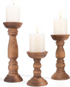 three wooden candlesticks with one candle lit and the other turned off in different positions