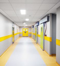 an empty hallway with yellow and gray doors