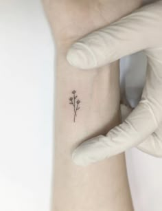 a small flower tattoo on the wrist