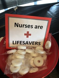 a red plate topped with donuts and a sign that says nurses are lifesavers