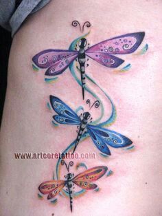 a woman's thigh with three dragon tattoos on it, one is purple and the other is blue