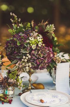 the table is set with flowers and plates