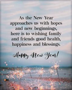 a happy new year card with sparklers on the beach and sky in the background