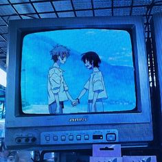 an old tv with anime characters on it's screen and people in the background