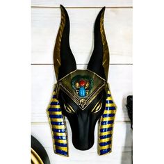 an egyptian mask is hanging on the wall