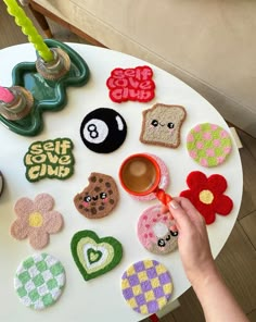 a person holding a cup in front of a table filled with different types of magnets