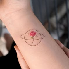 a woman's arm with a rose tattoo on the left side of her arm