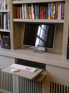 a computer monitor sitting on top of a white desk next to a keyboard and mouse