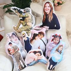 a woman sitting on top of a white couch next to pillows with pictures of people