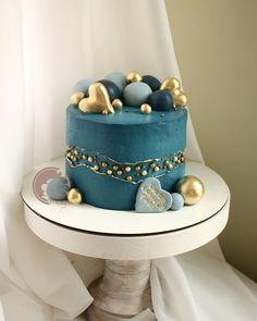 a blue cake with gold decorations on top