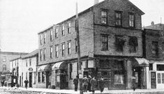 an old black and white photo of people in front of buildings