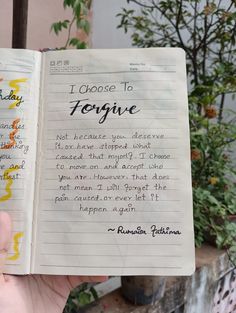 someone is holding up a book that has writing on it and the words i choose to forgive are written in cursive handwriting