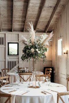 the table is set with white linens and tall centerpieces, along with flowers