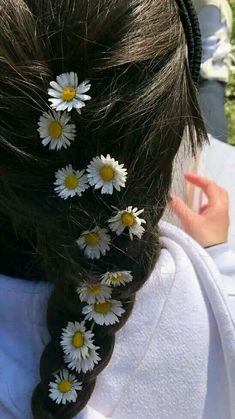 the back of a woman's head with daisies in her hair