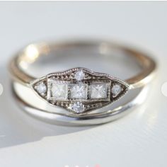 two wedding rings with diamonds on top of each other