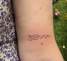 a woman's arm with a small tattoo of a car on the left side