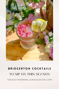 a glass filled with pink and white flowers on top of a wooden table