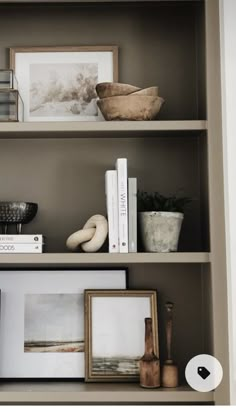 the shelves are filled with books, pictures and other things to put on top of them