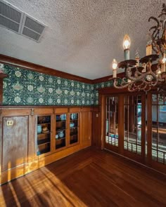 an empty room with wooden paneling and chandelier