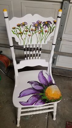 a white chair with purple flowers painted on it