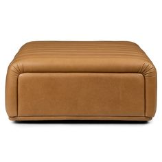 a tan leather ottoman sitting on top of a white floor