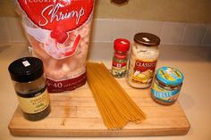 ingredients to make pasta sitting on a cutting board next to a bag of noodles and seasoning