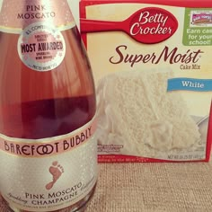 a bottle of pink moscato next to a package of creme and sugar