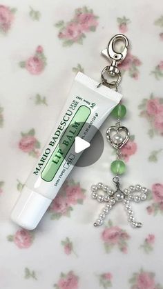 a tube of toothpaste sitting on top of a keychain next to a charm