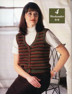 a woman sitting in a chair wearing a knitted vest