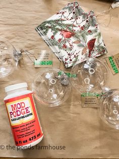 the table is covered with clear glassware and other items for making christmas decorations on it