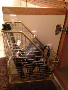 a metal basket filled with items on top of a carpeted floor next to a door