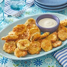 some fried food is on a plate with a small bowl of ranch dressing next to it