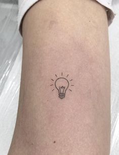 a small light bulb tattoo on the ankle