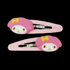 two pink hair clips with hello kitty on them