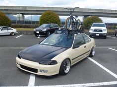 a car parked in a parking lot with a bike on the roof